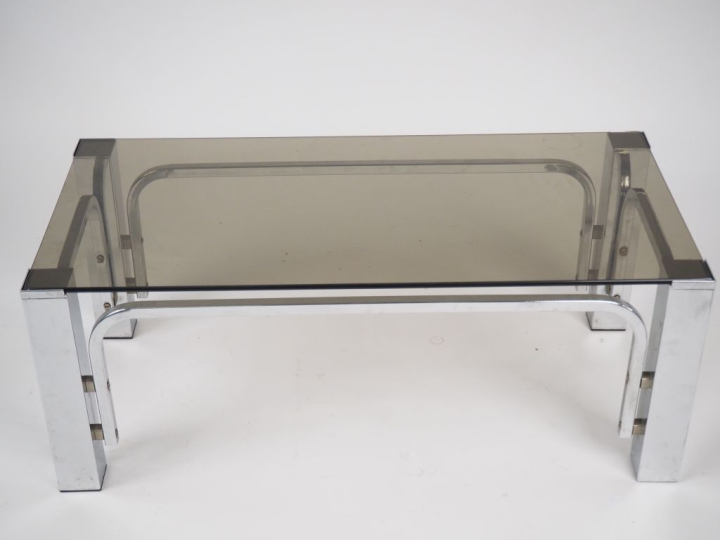 Table basse années 70 en métal chromé et verre fumé. Dim. 34,5 x 90 x 