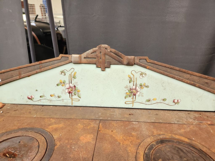 Cuisinière ancienne à décor émaillé de fleurs sur fond vert.