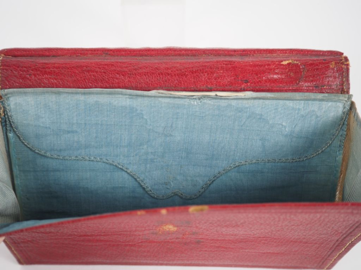 Portefeuille début XIXème en cuir et pomponne, fermeture à decor de ri