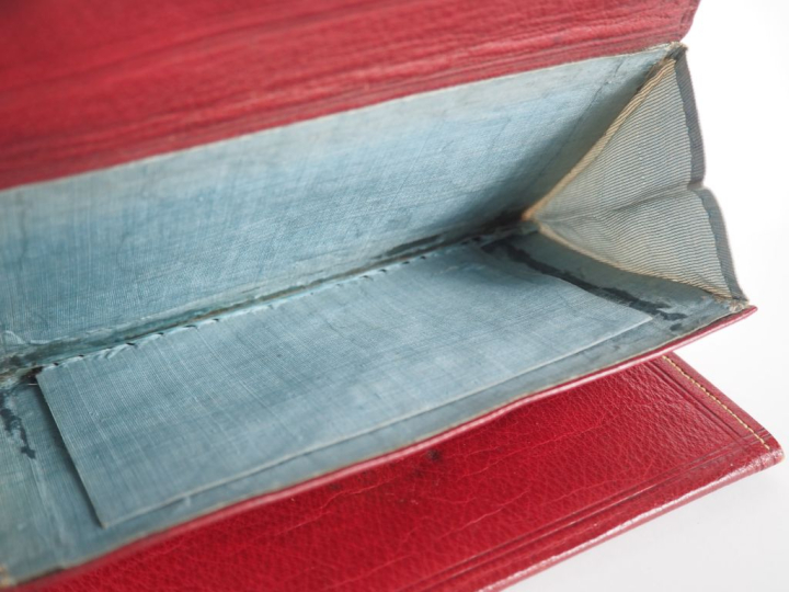 Portefeuille début XIXème en cuir et pomponne, fermeture à decor de ri