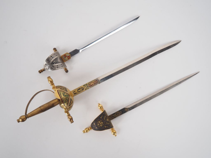 Trois différents ouvre-lettres en forme d'épées. L. de 17  à 26 cm.