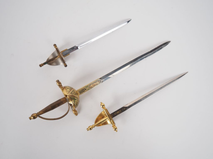 Trois différents ouvre-lettres en forme d'épées. L. de 17  à 26 cm.