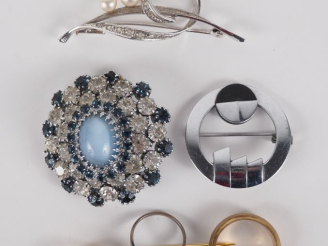 Vente aux enchères Ensemble comprenant :  - Une broche ronde en métal sertie de pierres f