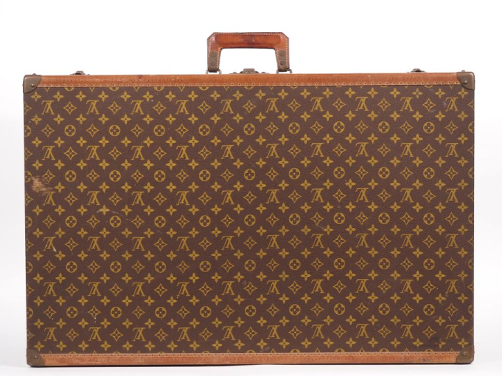 Louis VUITTON Valise rigide en toile enduite monogrammée.  Les bordure