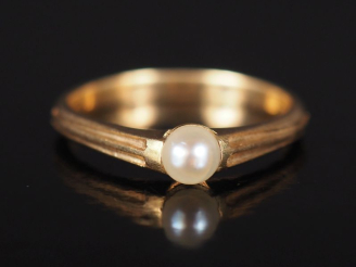 Vente aux enchères Bague jonc en or jaune 585, sertie en son centre d'une perle blanche. 
