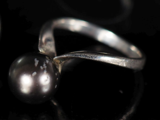 Vente aux enchères Bague en argent de forme stylisée, sertie d'une perle grise.  TDD. 51 
