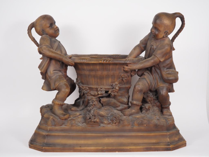 GOLDSCHEIDER.  Grande jardinière en stuc patiné figurant deux enfants 