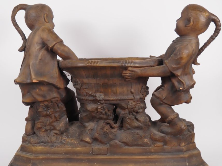GOLDSCHEIDER.  Grande jardinière en stuc patiné figurant deux enfants 