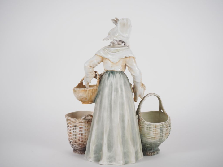 Vide poche en porcelaine polychrome figurant une jeune femme au panier