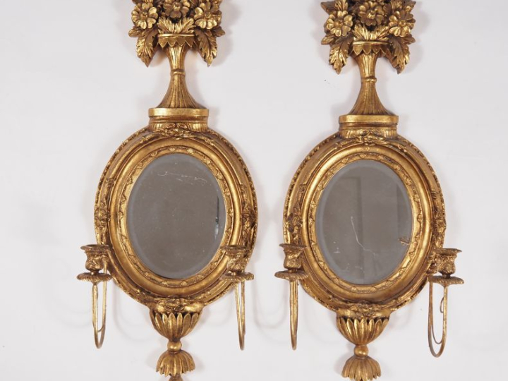 Paire de miroirs de style Louis XVI en bois doré à décor de fleurs et 