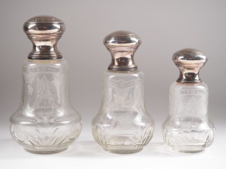 Suite de trois flacons de toilette de forme balustre en cristal gravé 