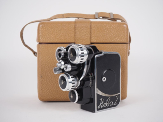 Vente aux enchères NEVA 2. Caméra 8mm avec ses accessoires dans sa sacoche.