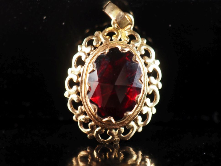 Pendentif en or jaune 750, serti en son centre d'un grenat.  Joli pour