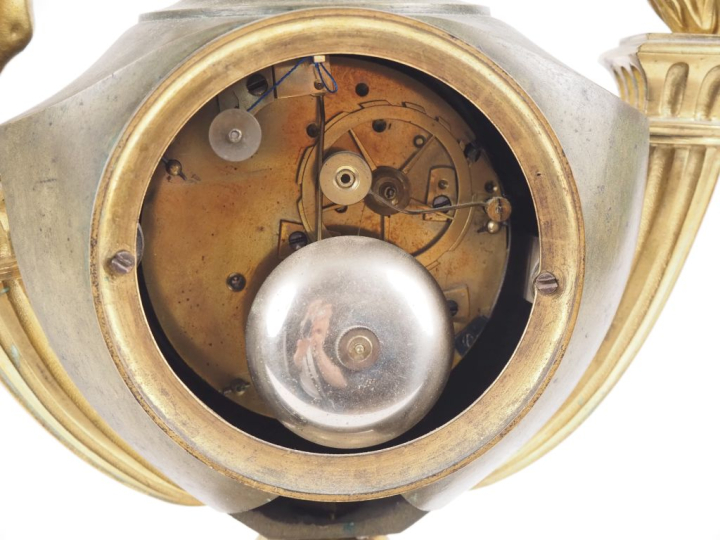 Pendule de style Empire en bronze, à double patine, figurant un amour 