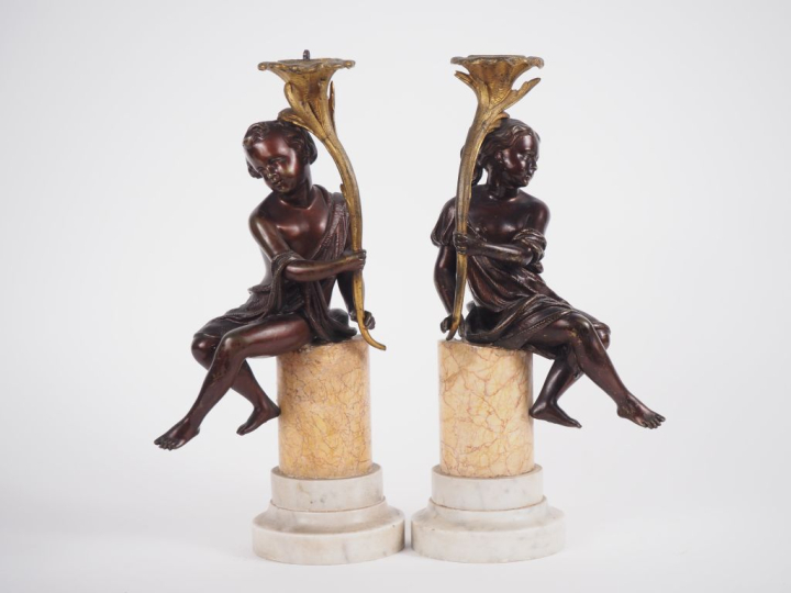 Paire de sujets en bronze à double patine figurant des amours portant 