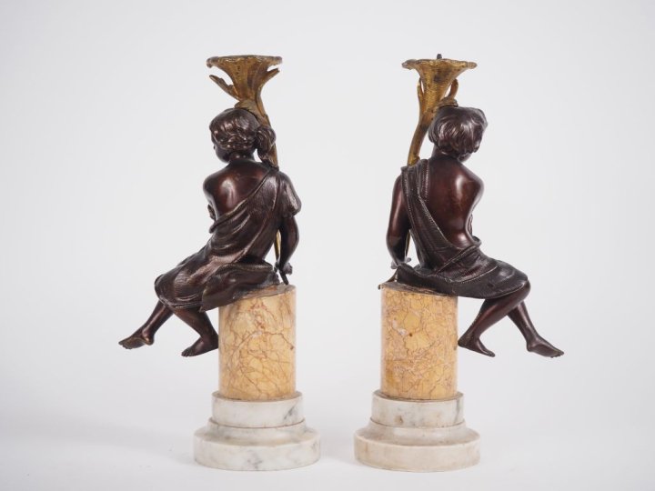 Paire de sujets en bronze à double patine figurant des amours portant 