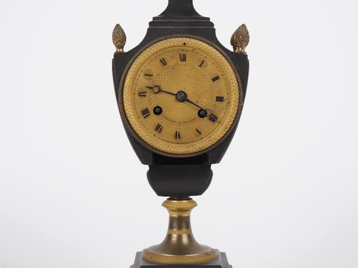Pendule de style Empire en bronze patiné et doré,  en forme d'écus, à 