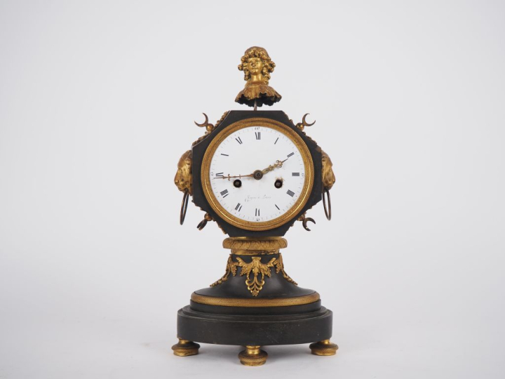 Pendule de style Empire en bronze patiné vert et doré, à décor de visa