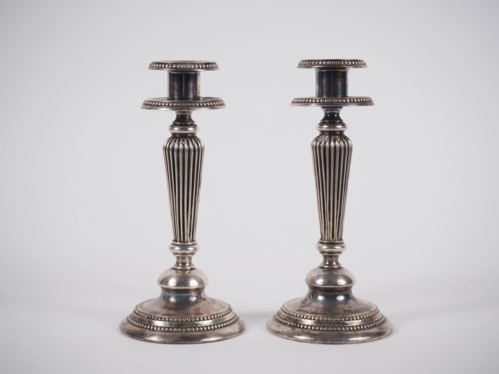 Paire de bougeoirs en métal argenté à décor de godrons et de frise de 