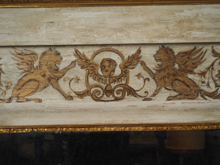 Miroir cadre en bois laqué gris, à décor de griffons, montants à colon