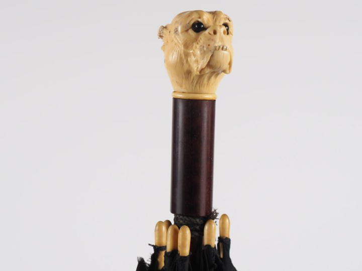 Parapluie 1900 en textile noir et bois, pommeau figurant une tête de d