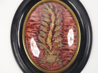Vente aux enchères Palme de récompense dans son cadre en bois noirci et velours de rouge.