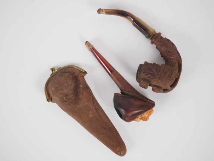 Deux différentes pipes en corne et bois sculpté, l'un figurant un visa