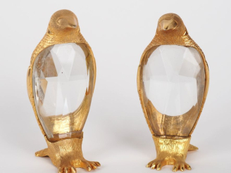 Vente aux enchères Paire de sujets en métal doré et verre taillé, "pingouins". H. 9,5 cm.