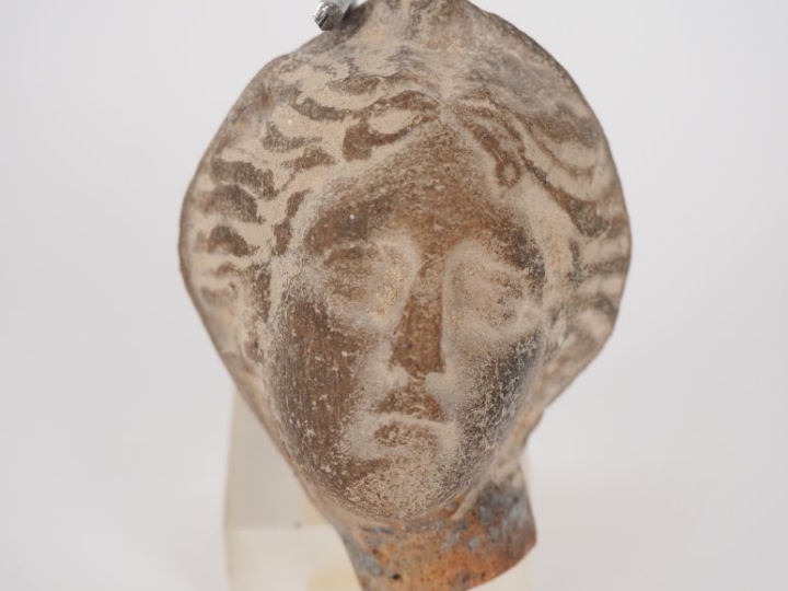 Tête de figurine de style antique en terre cuite. 6 cm