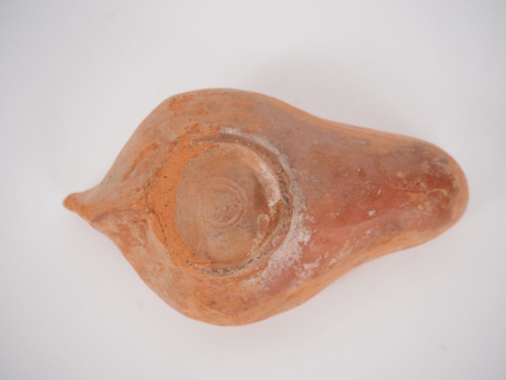 Lampe en terre cuite orné d’un visage de face sur le médaillon. Traces