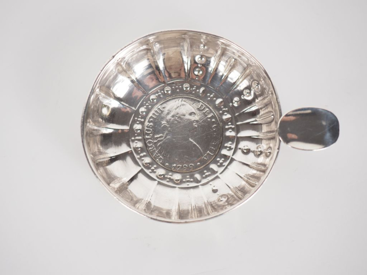 Taste-vin en argent, poinçon cygne, à décor de pétales.  Le fond agrém