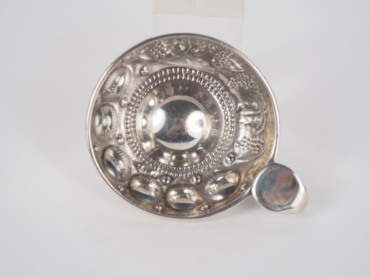 Taste-vin en argent 800, poinçon cygne, à décor de pampres.  Diam. 7,6