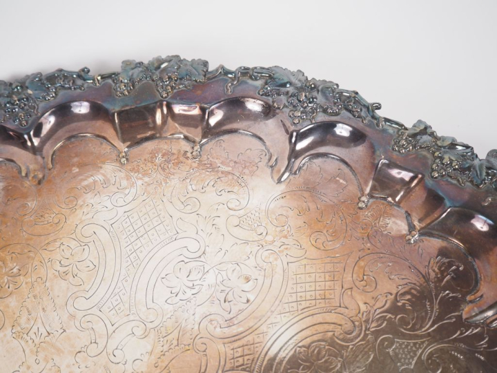 Grand plateau ovale sur pieds en métal argenté, à décor de pampres et 