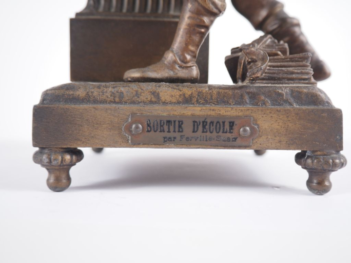 FERVILLE Suan. Pendule en régule patiné "sortie d'école". H. 32 cm