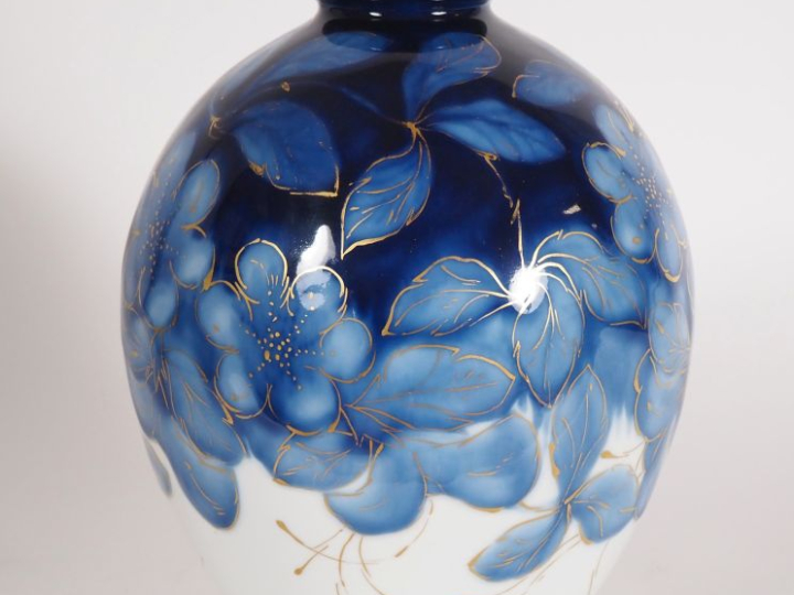 THARAUD. Vase ovoide en porcelaine à décor de fleurs et de feuillage e