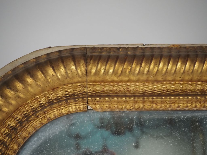 Glace de cheminée Napoléon III en bois et stuc doré, cadre guilloché. 