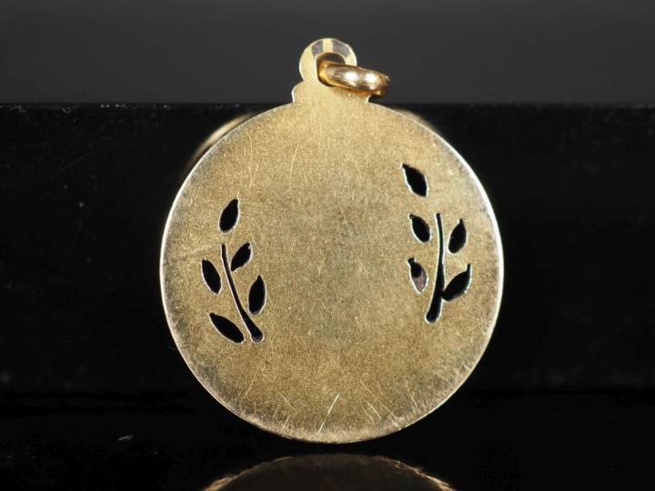 Médaille religieuse en or jaune 750, figurant une petite sainte les ma