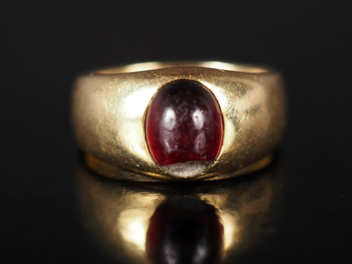 Bague en or jaune 750, sertie en son centre d'un cabochon de pierre du