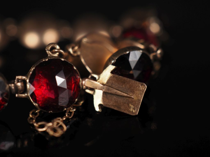 Bracelet souple en or jaune 750, serti de grenats.  Chainette de sécur