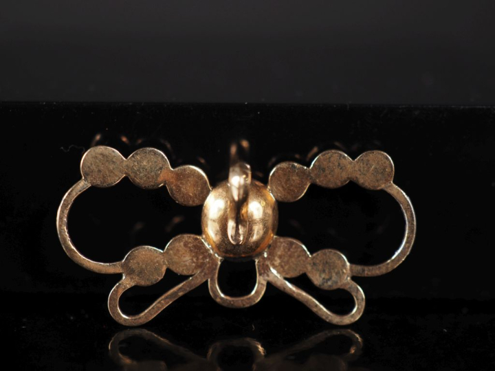 Pendentif ajouré en or jaune 585, à décor ajouré et serti de grenats. 