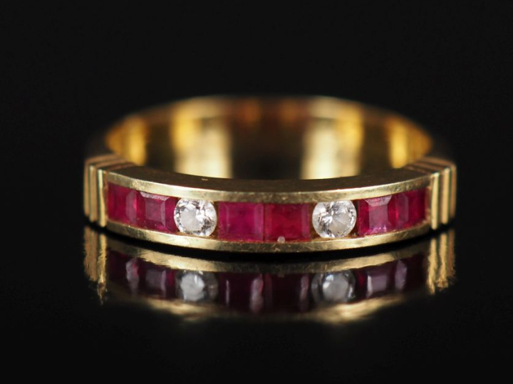 Bague jonc en or jaune 750, sertie de rubis calibrés et de deux petits