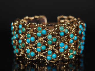 Vente aux enchères Bracelet manchette articulé ajouré en or jaune bas titre, serti d'imit