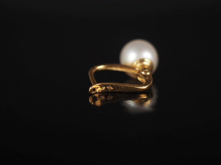 Paire de perces oreilles en or jaune 750, sertis d'une perle blanche. 
