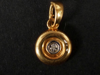 Vente aux enchères Pendentif en or jaune 750, serti en son centre d'un petit diamant.  Di
