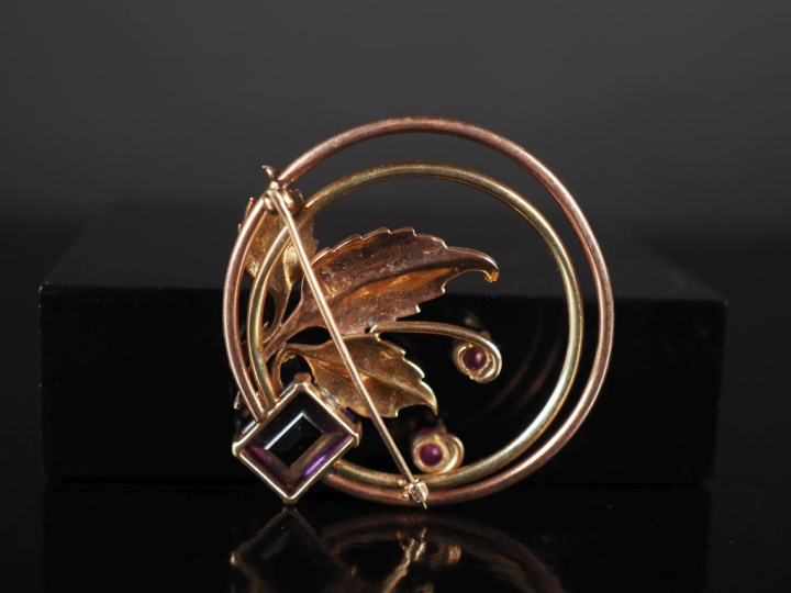 Broche circulaire ajourée deux tons d'or 375, à décor de branchage fle