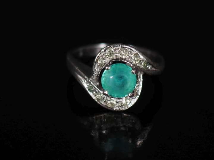 Bague tourbillon en argent, sertie en son centre d'une pierre verte et