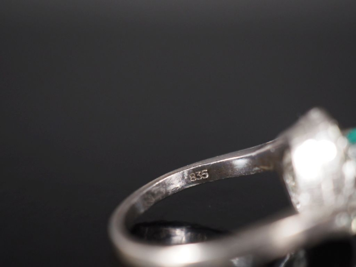 Bague tourbillon en argent, sertie en son centre d'une pierre verte et