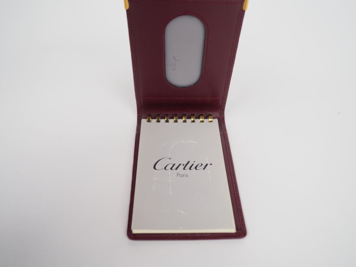 CARTIER, Paris Protège carnet en cuir bordeaux.  Deux coins gainés de 