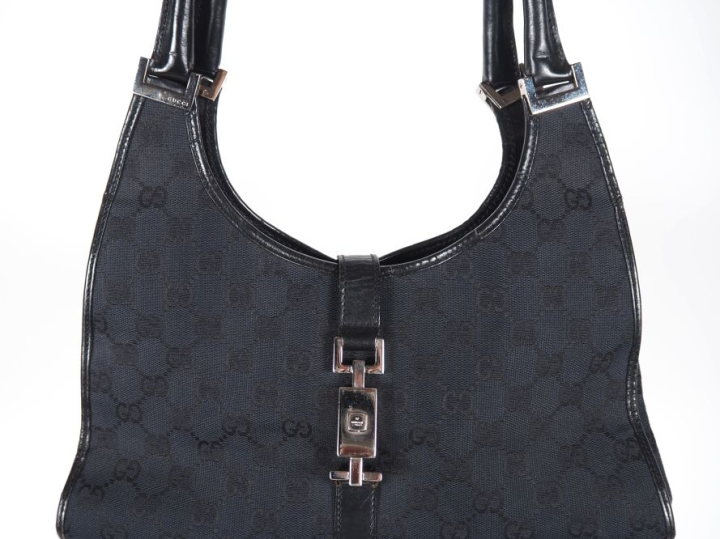 GUCCI Sac porté épaule, modèle "Jackie", en toile monogrammée noire.  