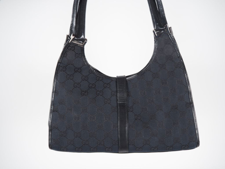 GUCCI Sac porté épaule, modèle "Jackie", en toile monogrammée noire.  